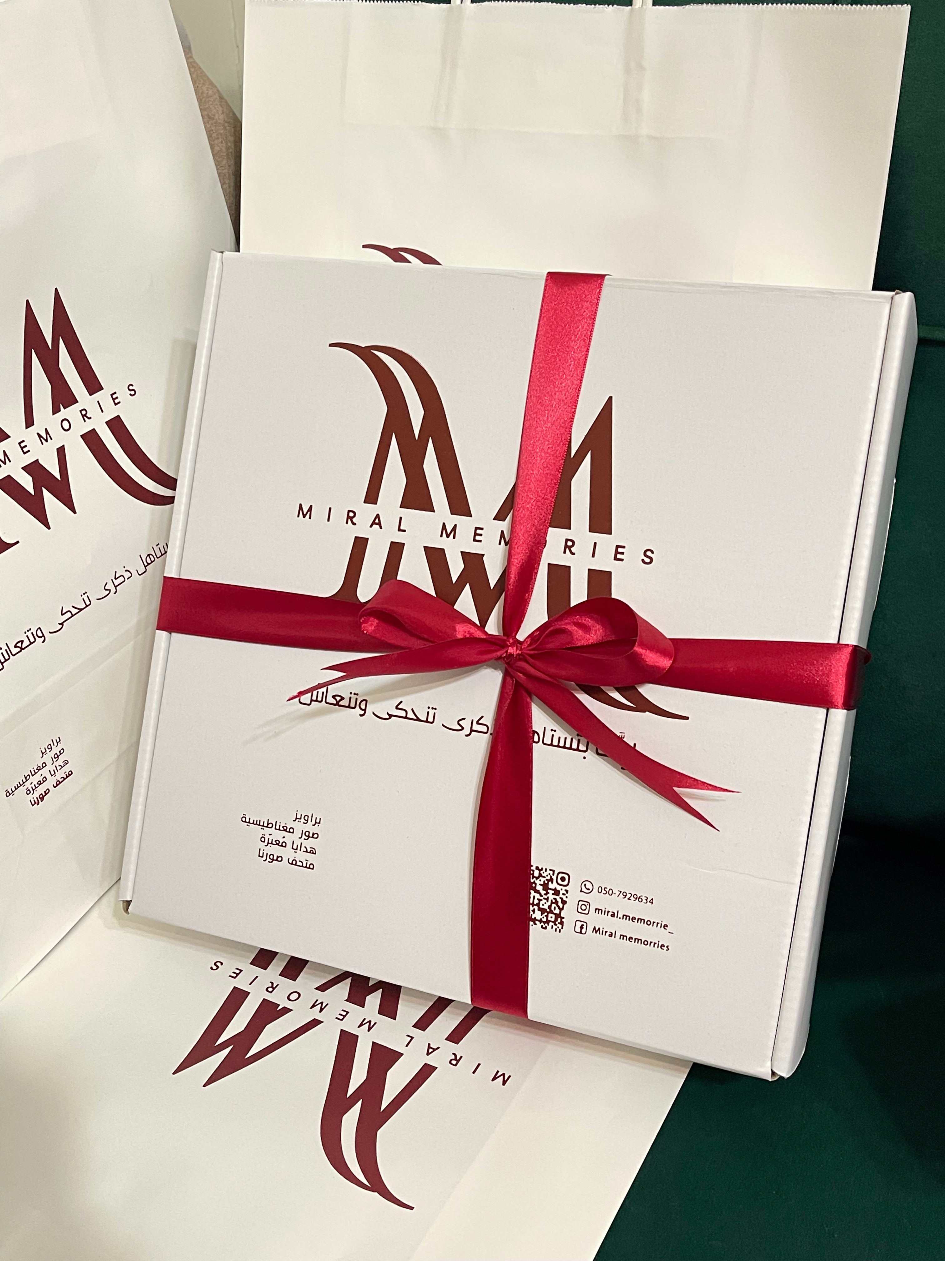 Gift box with red ribbon and 'Miral Memories' branding on a white background